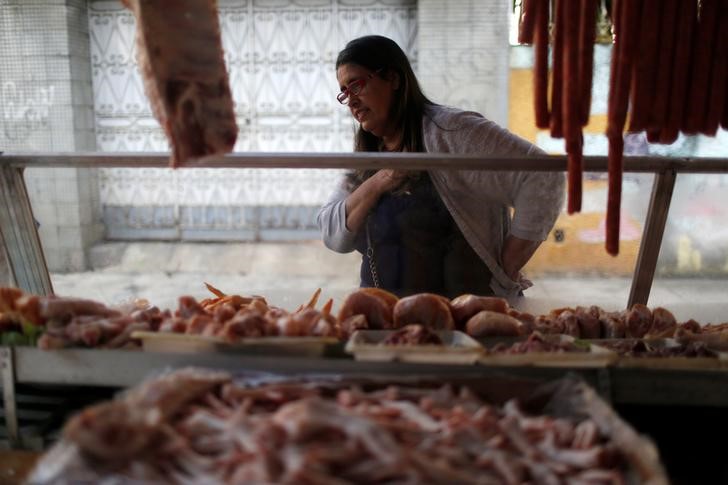 © Reuters. Mulher observa banca com carnes em feira do Rio de Janeiro