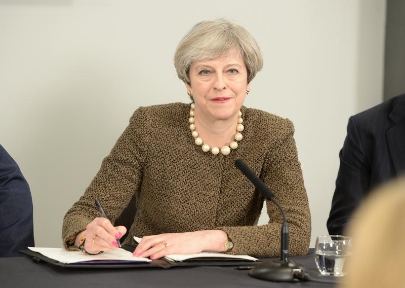 © Reuters. Britain's Prime Minister Theresa May signs a Swansea City deal during a meeting at the Liberty Stadium in Swansea