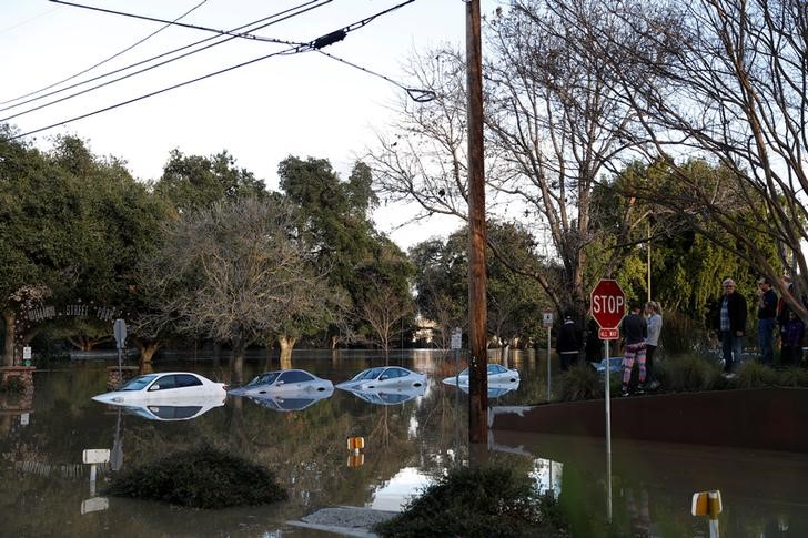 © Reuters. Vehicles are seen partially submerged in flood water at William Street Park after heavy rains overflowed nearby Coyote Creek in San Jose