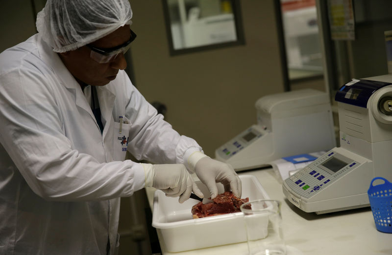 © Reuters. A veterinarian analyses a piece of meat collected by Public Health Surveillance agents during an inspection of supermarkets, at a veterinary laboratory with the public health department in Rio de Janeiro