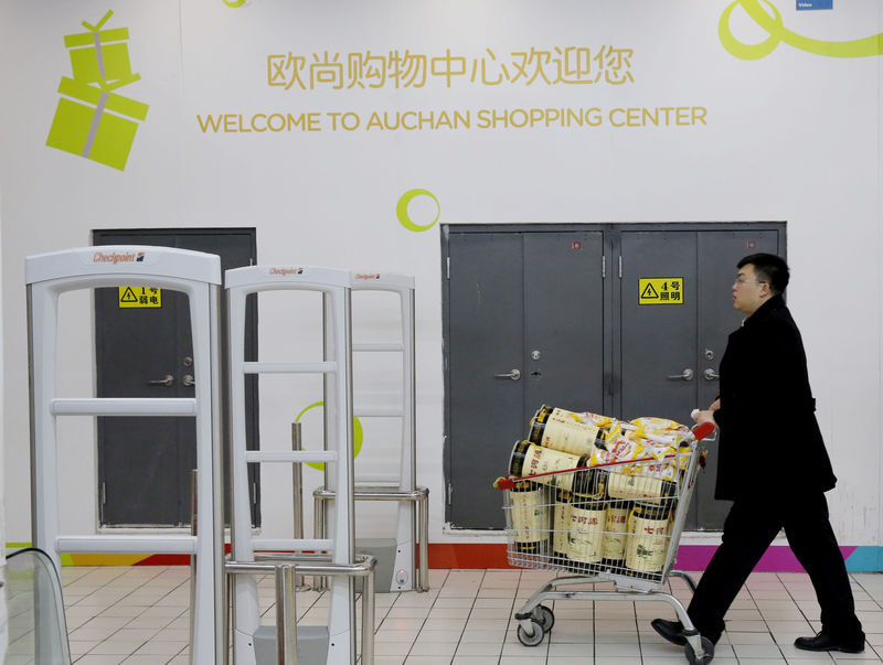 © Reuters. FILE PHOTO: A customer pushes a shopping cart at Sun Art Retail Group's Auchan hypermarket store in Beijing