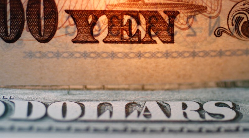 © Reuters. FILE PHOTO: The word "Yen" is pictured on a Japanese banknote on top of a U.S. dollar bill at Interbank Inc. Money exchange in Tokyo