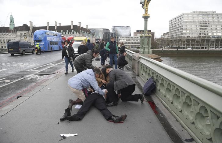 © Reuters. Pessoas feridas são socorridas na ponte de Westminster em Londres