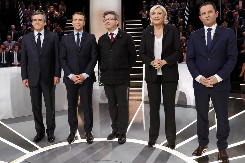 © Reuters. French presidential election candidates Francois Fillon, Emmanuel Macron, Jean-Luc Melenchon, Marine Le Pen and Benoit Hamon, pose before a debate organised by French private TV channel TF1 in Aubervilliers