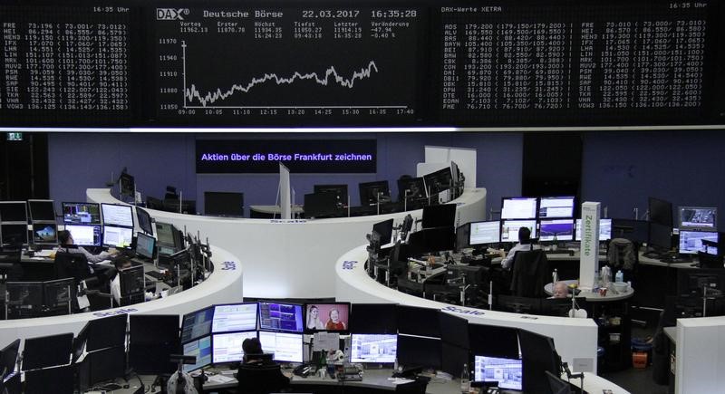 © Reuters. Traders work at their desks in front of the German share price index DAX board in Frankfurt