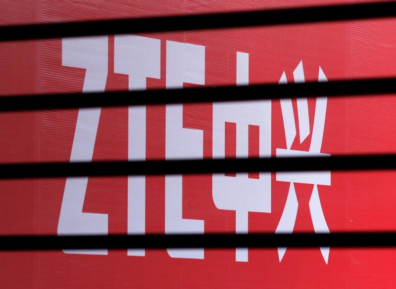 © Reuters. FILE PHOTO - The company logo of ZTE is seen through a wooden fence on a glass door during the company's 15th anniversary celebration in Beijing