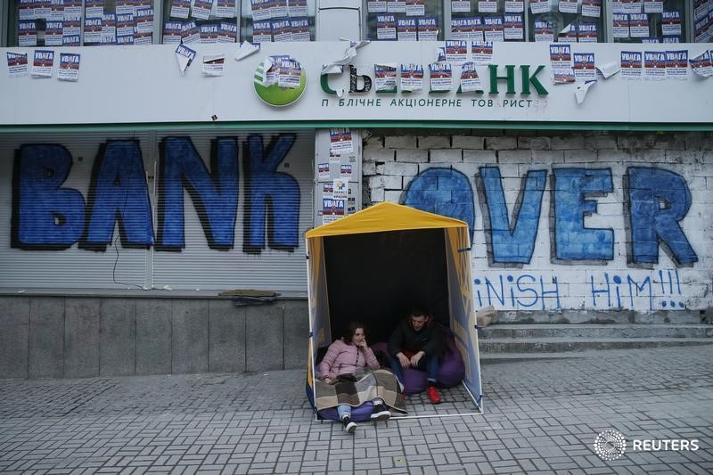 © Reuters. Люди протестуют у отделения Сбербанка в Киеве