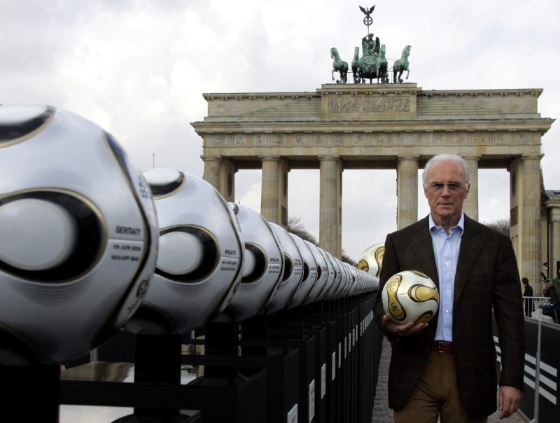 © Reuters. President of Germany's World Cup organising committee Beckenbauer holds a soccer ball in Berlin