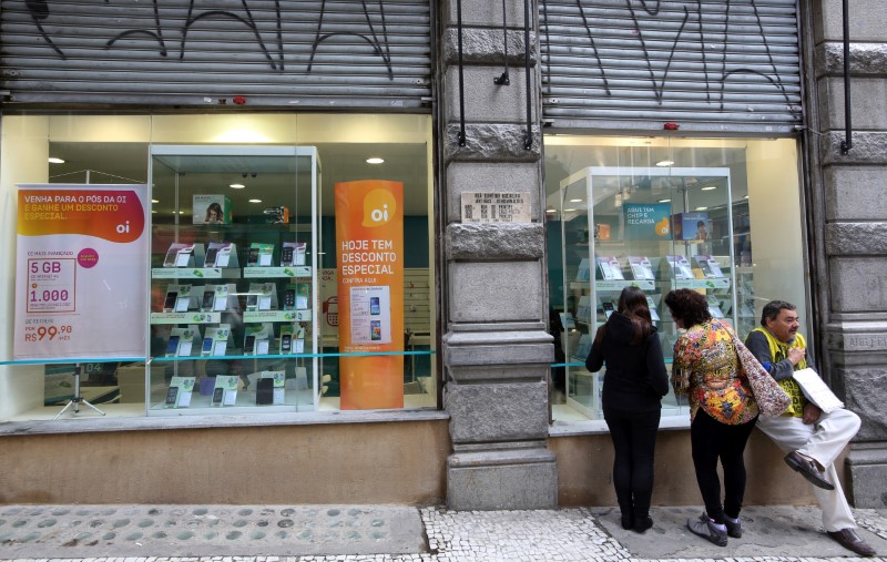 © Reuters. Consumers stand in front of an Oi store, Brazil's largest fixed-line telecoms group, in Sao Paulo