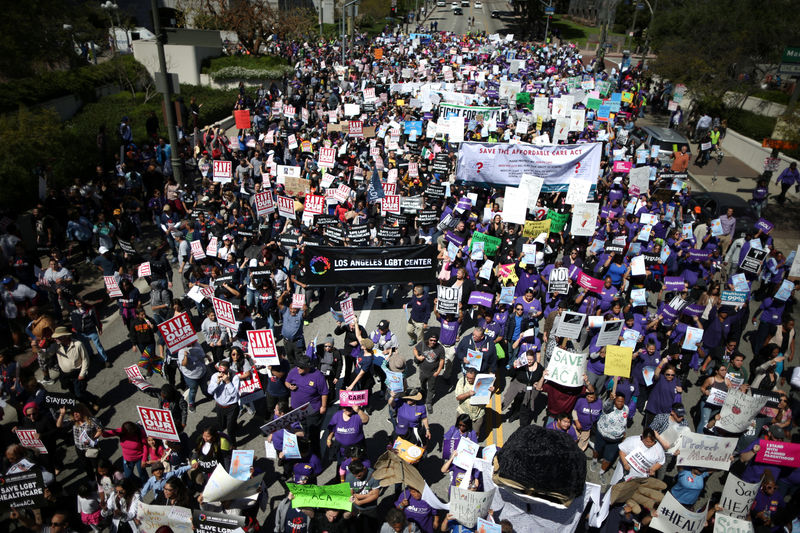 © Reuters. People march in a "Save Obamacare" rally on the seventh anniversary of Obamacare's signing, in Los Angeles