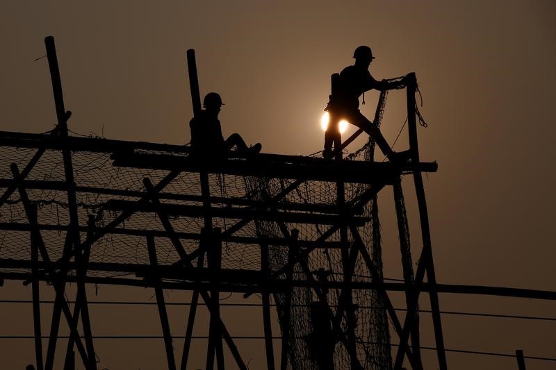 © Reuters. Workers build a wooden scaffolding at a construction site in Beijing