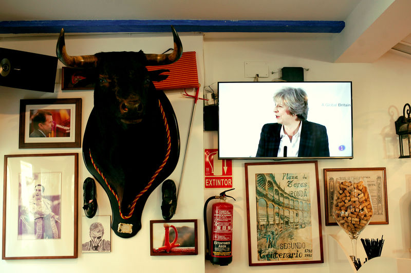 © Reuters. FILE PHOTO: Britain's Prime Minister Theresa May is seen on a television screen next to a mounted bull's head during a prime time news broadcast at a restaurant in Fuengirola