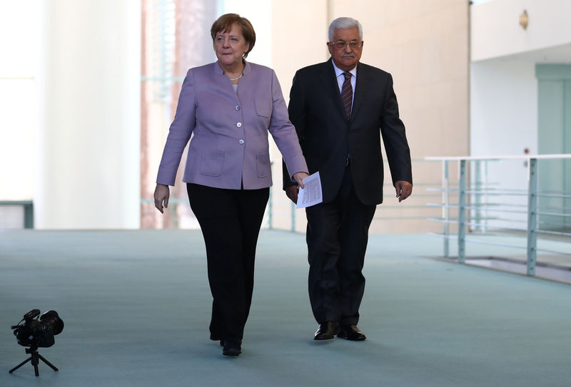 © Reuters. German Chancellor Merkel and Palestinian President Abbas arrive for a statement in Berlin