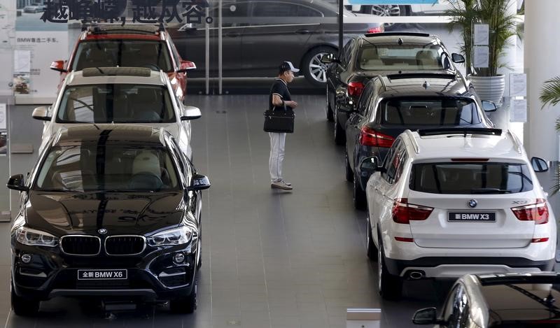 © Reuters. A man takes a look at BMW cars at a dealer shop in Beijing