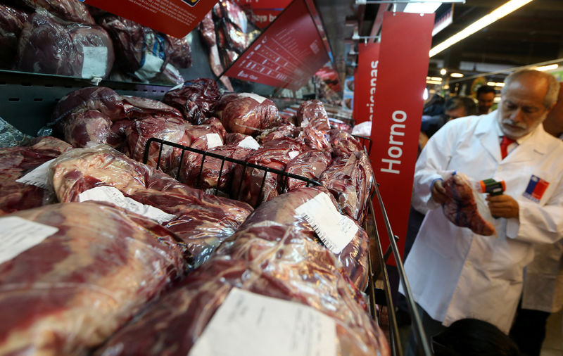 © Reuters. A member of the Public Health Surveillance Agency measures the temperature where the products are exposed at a supermarket after the Chilean government suspended all meat and poultry imports from Brazil, in Santiago,