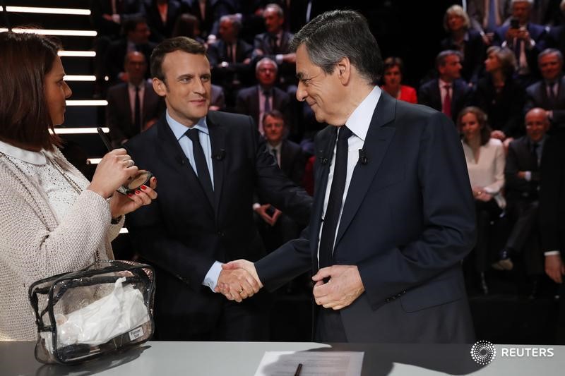 © Reuters. Candidates for the 2017 presidential election Fillon and Emmanuel Macron pose before a debate organised by French private TV channel TF1 in Aubervilliers