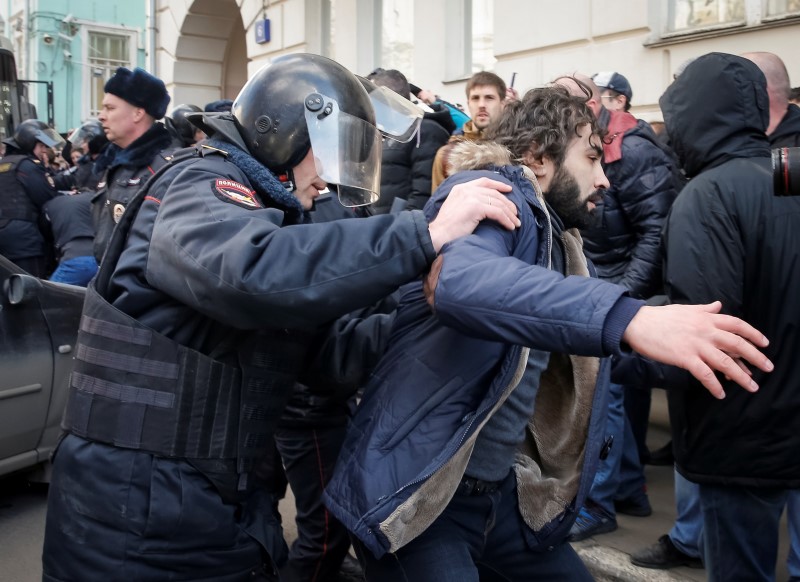 © Reuters. A law enforcement officer detains an opposition supporter during a rally in Moscow, Russia