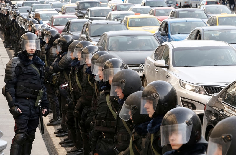 © Reuters. Law enforcement officers line up along a street as they block a rally in Moscow