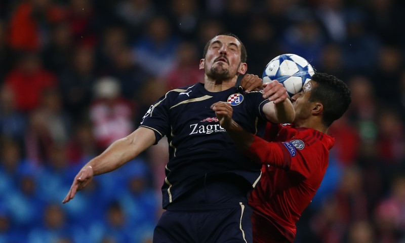 © Reuters. Dinamo Zagreb's Ademi goes for a header with Bayern Munich's Alcantara during their Champions League Group F soccer match in Munich