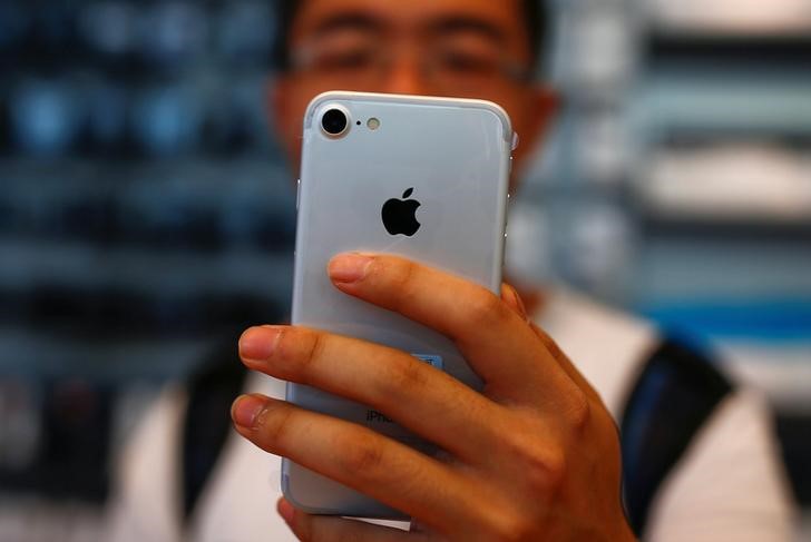 © Reuters. Homem segura seu iPhone em loja da Apple em Pequim