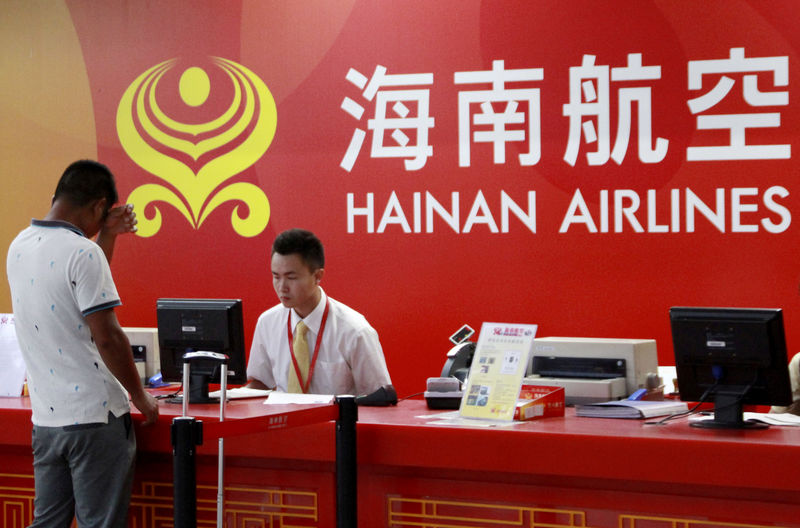 © Reuters. FILE PHOTO: A customer stands in front of a counter of Hainan Airlines at an airport in Haikou