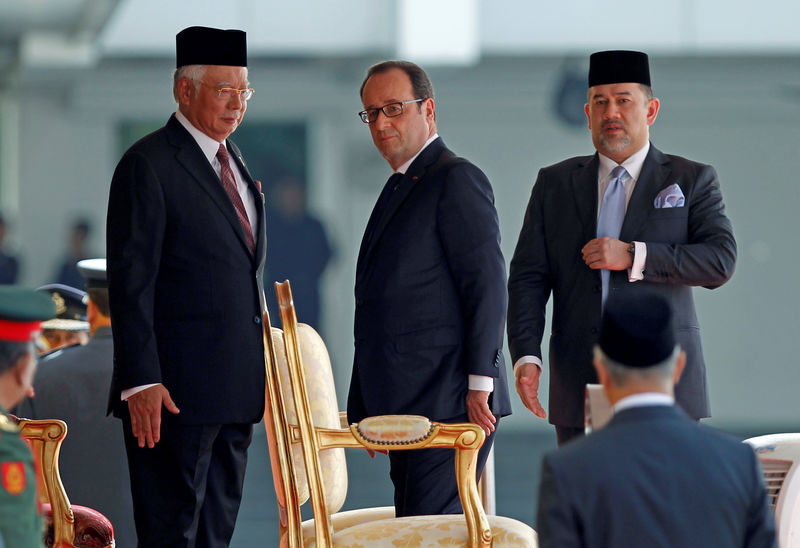 © Reuters. French President Francois Hollande walks with Malaysia's Prime Minister Najib Razak and King Muhammad V after a welcome ceremony at the Parliament House in Kuala Lumpur