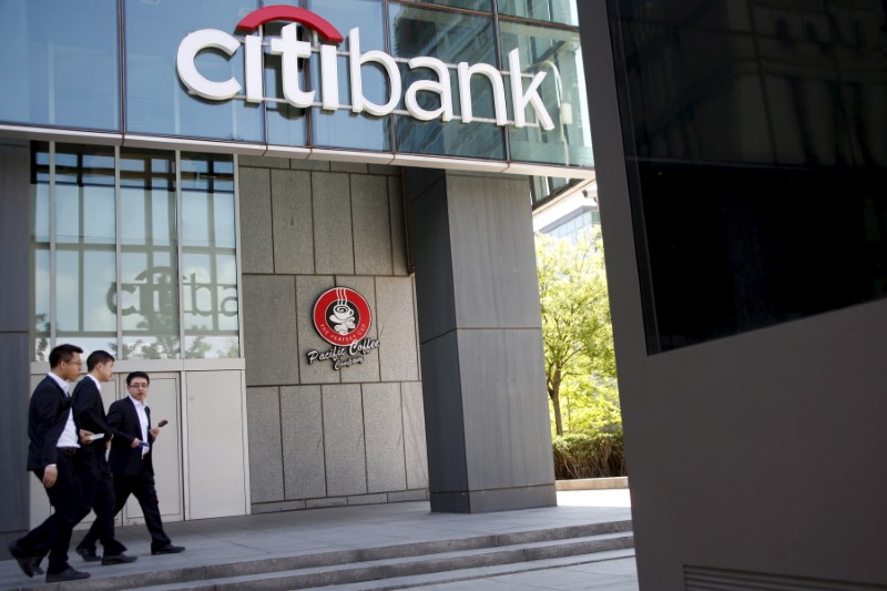 © Reuters. People walk past a branch of Citibank in Beijing