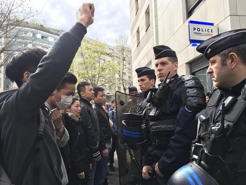 © Reuters. Membros da comunidade chinesa protestam em frente a uma delegacia de polícia de Paris