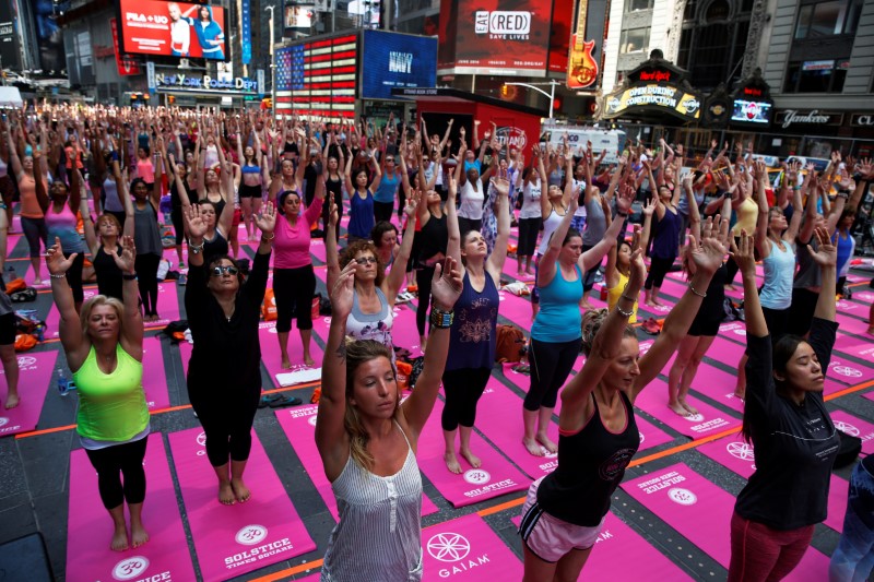 © Reuters. People participate in a yoga class during the 14th Annual Solstice in Times Square event in New York