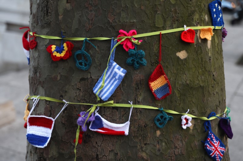 © Reuters. Knitted European flags hang from a ribbon tied around a tree during a protest in favour of amendments to the Brexit Bill outside the Houses of Parliament, in London