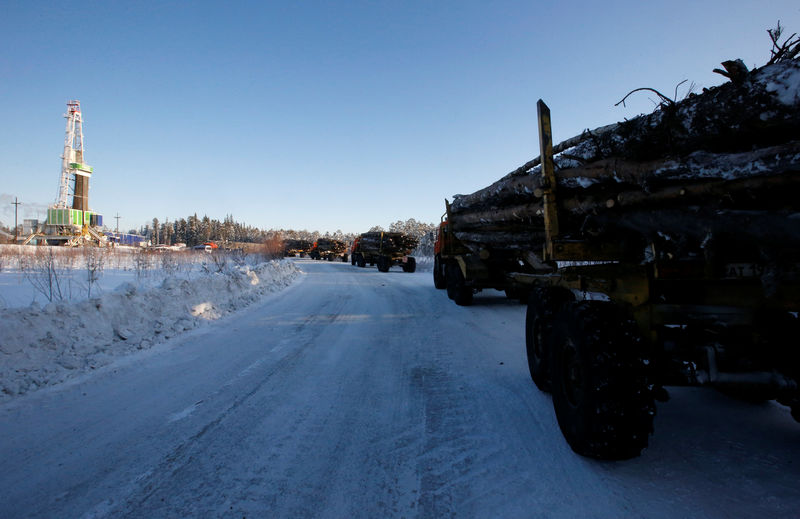 © Reuters. FILE PHOTO: Trucks carry wood for making a drill pad at Rosneft's Samotlor oil field outside the West Siberian city of Nizhnevartovsk, Russia