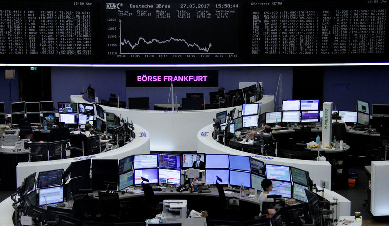 © Reuters. Traders work at their desks in front of the German share price index DAX board in Frankfurt