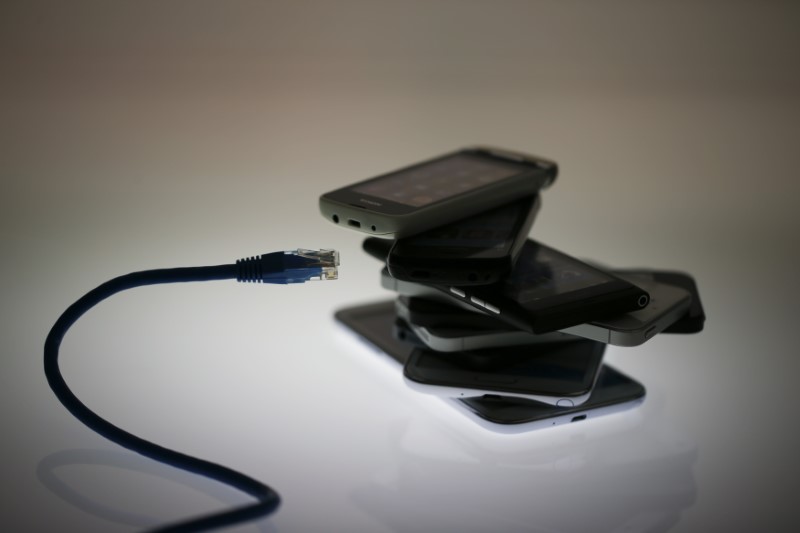 © Reuters. An illustration picture shows a network cable next to a pack of smartphones in Berlin