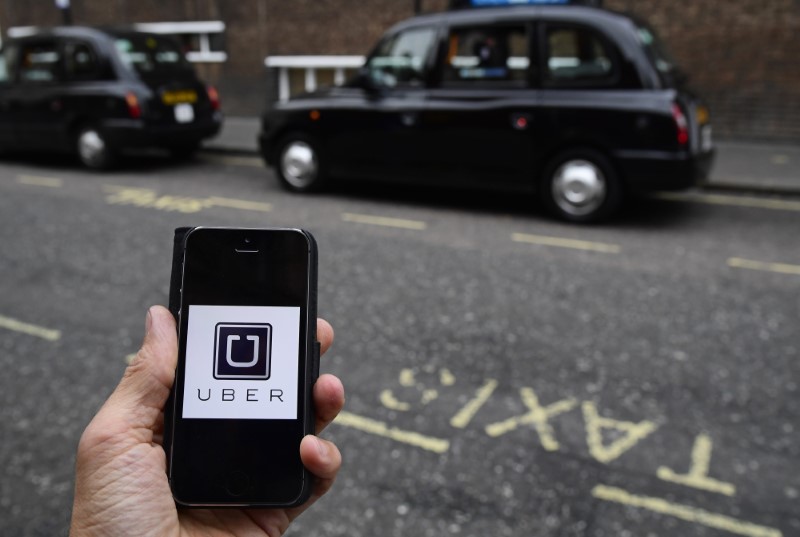 © Reuters. A photo illustration shows the Uber app logo displayed on a mobile telephone, as it is held up for a posed photograph in central London