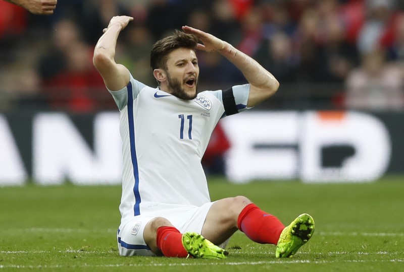 © Reuters. England's Adam Lallana reacts after being fouled