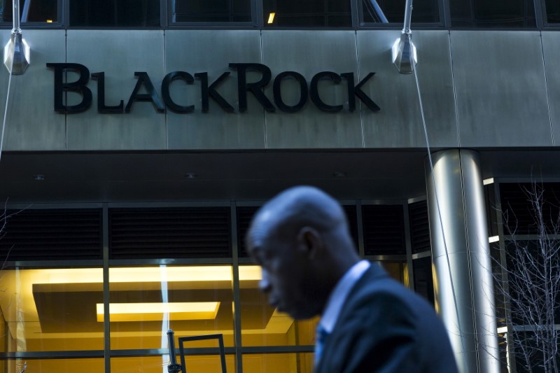 © Reuters. A man walks next to a BlackRock sign pictured in the Manhattan borough of New York