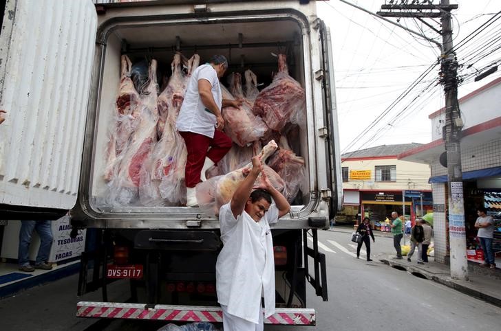 © Reuters. Funcionários de açougue descarregam carnes de caminhões em São Paulo