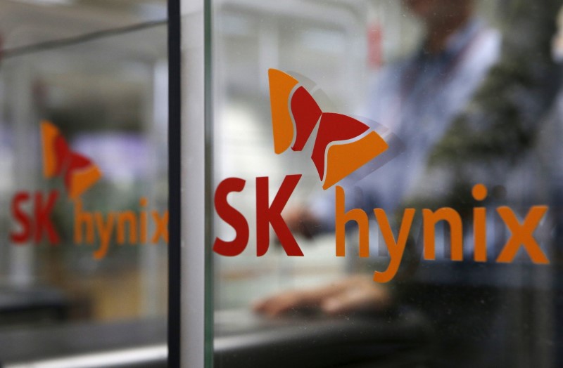 © Reuters. Employee walks past the logo of SK Hynix at its headquarters in Seongnam
