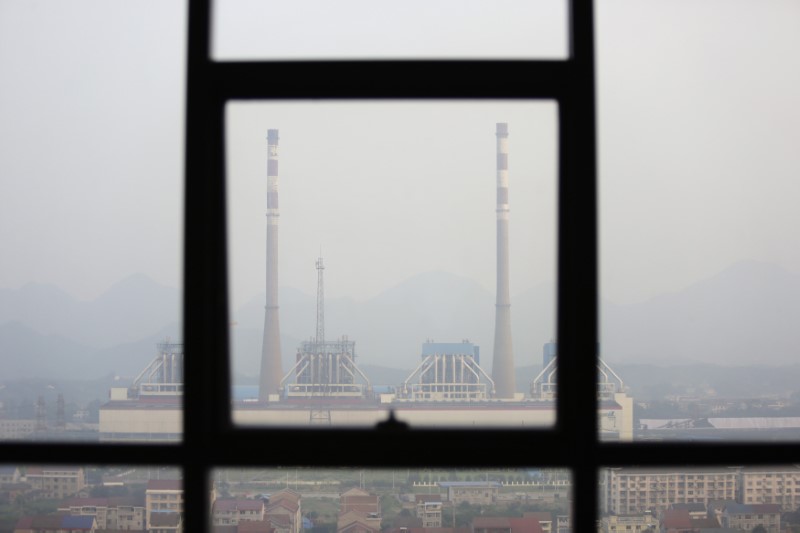 © Reuters. Chimneys are seen through a window at a coal-fired power plant on a hazy day in Shimen county