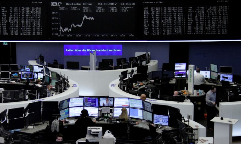 © Reuters. Traders work at their desks in front of the German share price index DAX board in Frankfurt