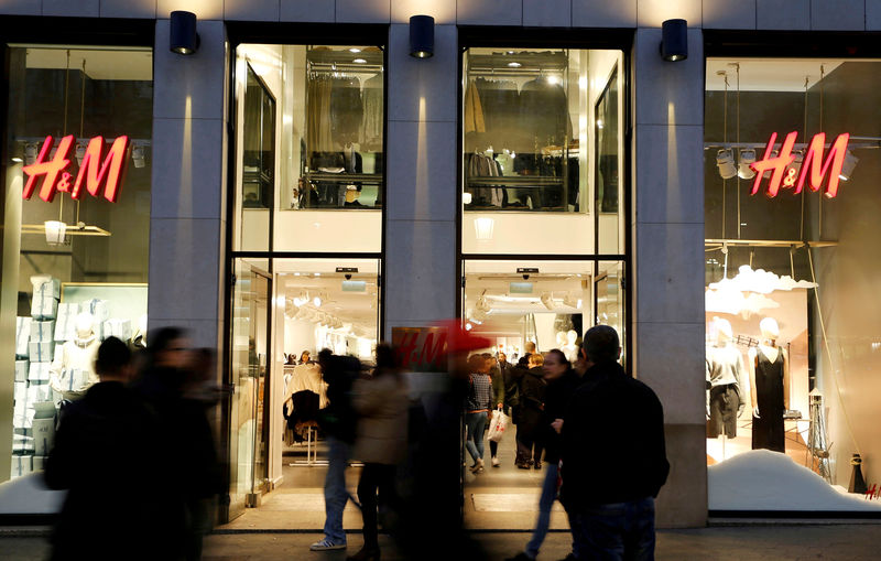 © Reuters. FILE PHOTO: People walk past the windows of an H&M store in Barcelona