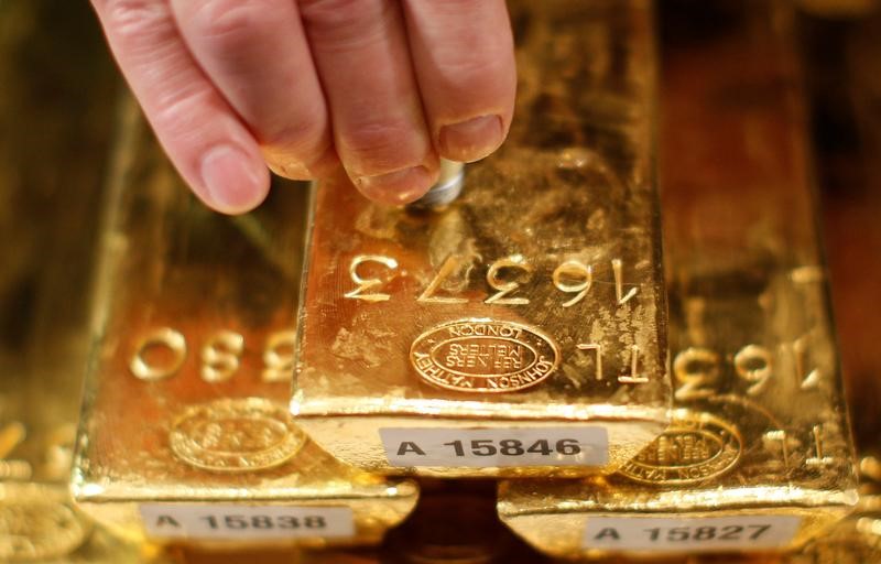 © Reuters. الذهب يتراجع مع صعود الدولار لكن حالات الضبابية تحد من الخسائر