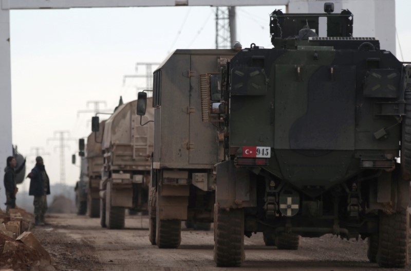 © Reuters. FILE PHOTO: Free Syrian Army fighters gesture as Turkish military vehicles drive in the Syrian rebel-held town of al-Rai while heading towards the northern Syrian town of al-Bab