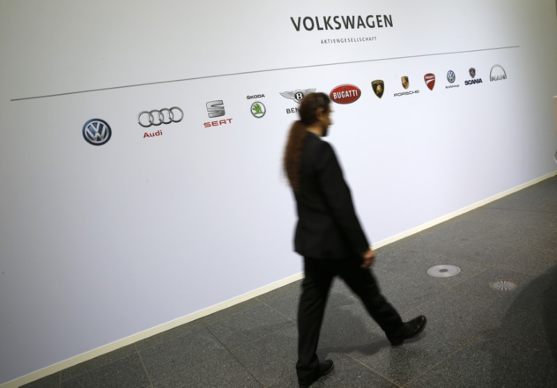 © Reuters. A man walks past the brands of the Volkswagen group during the annual news conference in Wolfsburg