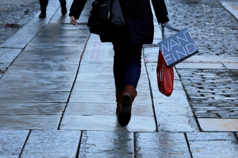 © Reuters. FILE PHOTO: A shoppers carries bags with purchases through Quincy Market in downtown in Boston