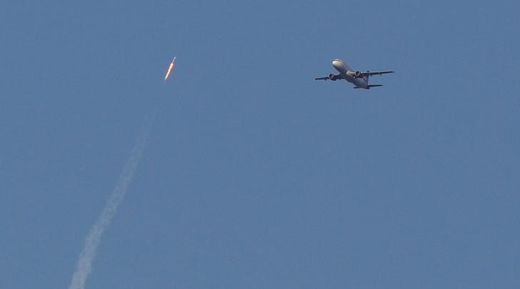 © Reuters. Um foguete reciclado SpaceX Falcon 9 sobe em direção ao espaço acima de um avião de passageiros da Virgin Airlines, que acabara de sair do Aeroporto Internacional de Orlando, em Orlando