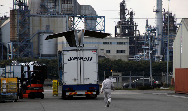 © Reuters. Worker walks near a factory at the Keihin industrial zone in Kawasaki