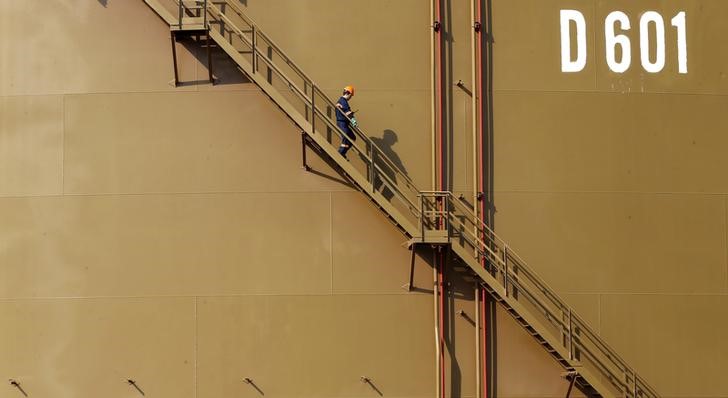 © Reuters. Рабочий спускается по лестнице нефтехранилища в порту Джейхан, Турция