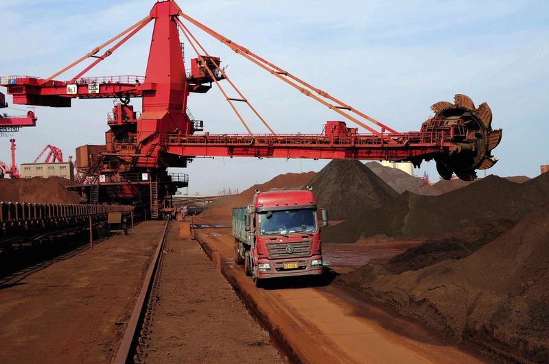 © Reuters. A truck drives past piles of iron ore at the dump site of a port in Rizhao