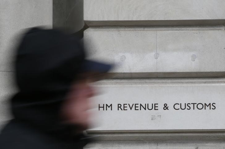 © Reuters. File photo of a pedestrian walking past the headquarters of Her Majesty's Revenue and Customs (HMRC) in central London